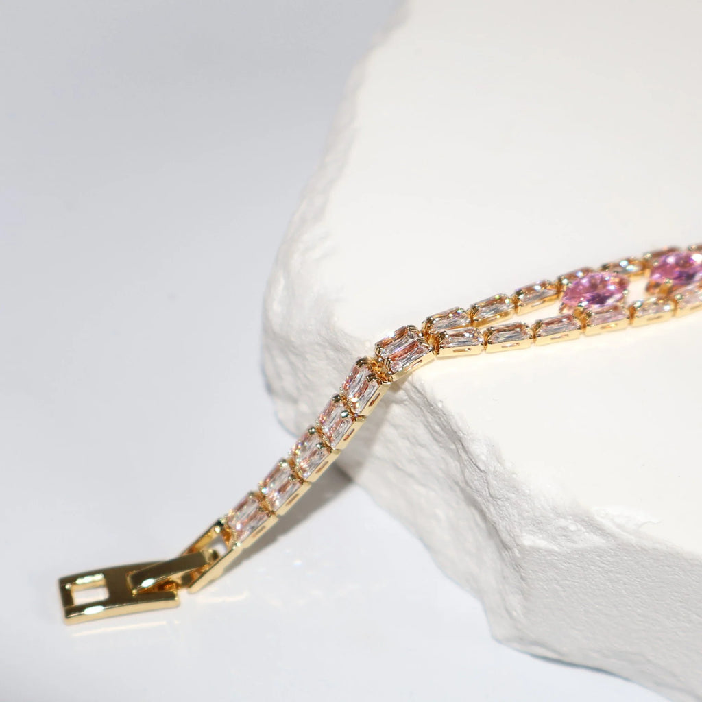 Close-up of pink zircon bow bracelet with gold setting