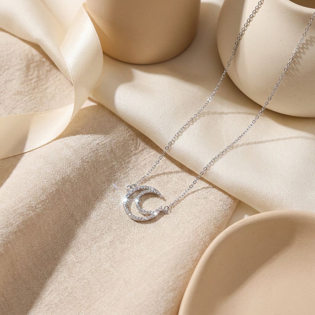 Celestial moon pendant necklace with zirconia stones styled on elegant beige backdrop