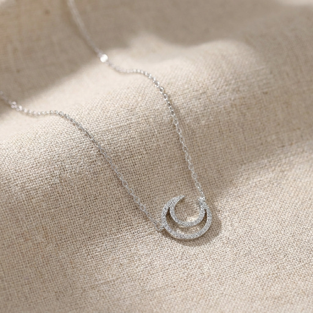Elegant celestial moon necklace worn by female model in natural light
