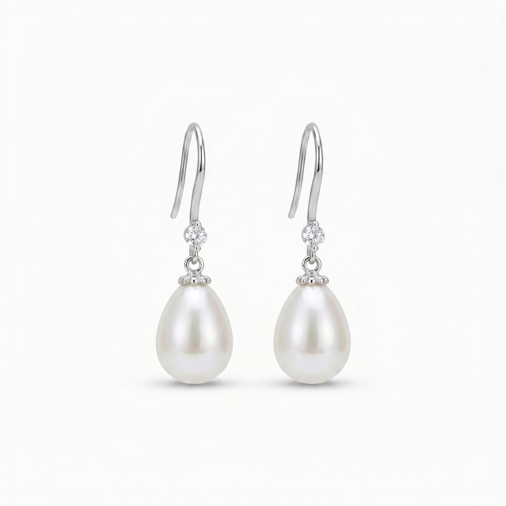 Close-up of 925 sterling silver pearl drop earrings featuring natural freshwater pearls and zirconia stones, worn by a bride
